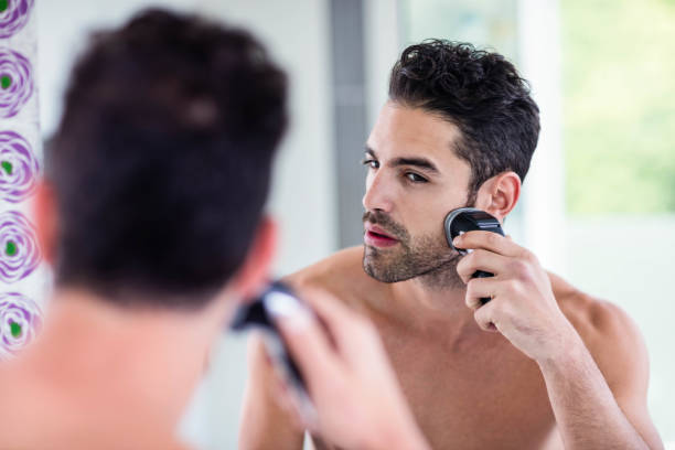 istock Handsome man shaving in the mirror 846251916