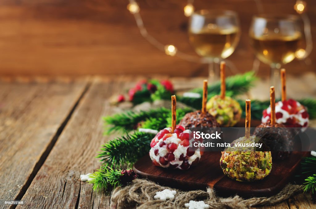 Variation of goat cheese balls appetizer with pistachio, pomegranate and flax seeds Variation of goat cheese balls appetizer with pistachio, pomegranate and flax seeds. toning. selective focus Christmas Stock Photo