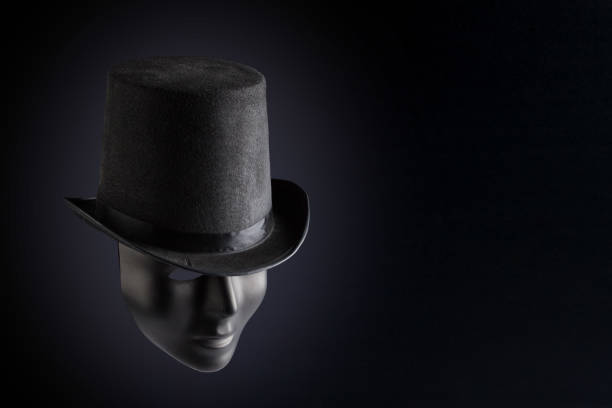 istock Black mask face wearing black top hat on black background with copy space. Social masking and mystery concept 846255564