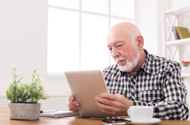istock Senior man reading news on digital tablet 846258250