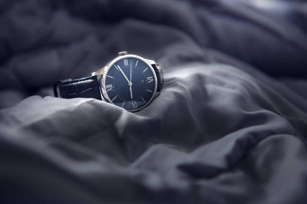 Closeup luxury man wrist watch black dial on gray fabric background. Dark toned.
