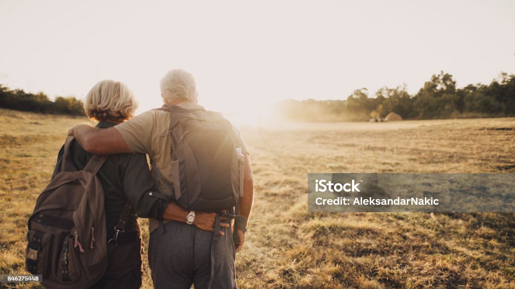 Senior couple hiking Photo of an elderly couple who still enjoy making memories, searching for new adventures while backpacking; wide photo dimensions Senior Couple Stock Photo