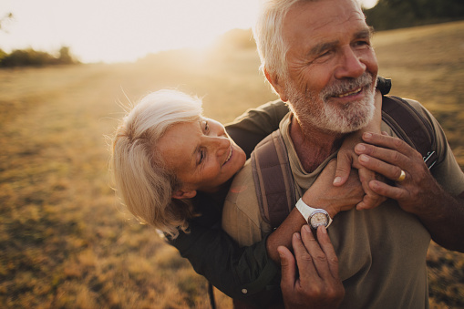 Photo of an elderly couple, who still enjoy in each other, is on a hiking trip together