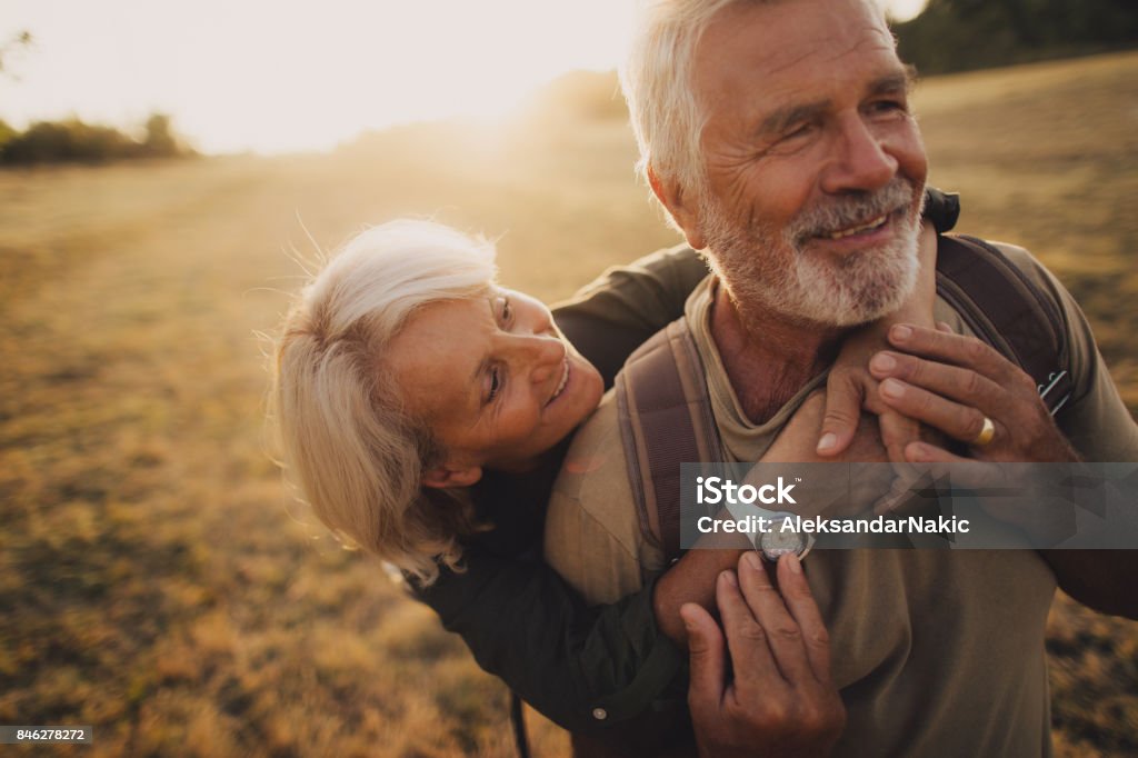 Senior Tenderness Photo of an elderly couple, who still enjoy in each other, is on a hiking trip together Senior Adult Stock Photo