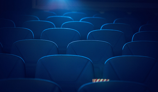Empty cinema's blue seats and popcorn.