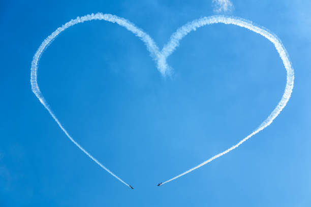 Moscow, Russia - July 21, 2017: A heart in the blue sky from two skywriting small planes at an air show. MAKS-2017.