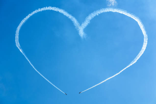 A heart in the sky from planes Moscow, Russia - July 21, 2017: A heart in the blue sky from two skywriting small planes at an air show. MAKS-2017. moscow international air show stock pictures, royalty-free photos & images
