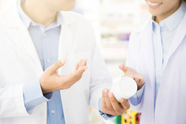 istock Pharmacist holding medicine bottle and discussing in pharmacy 846299612