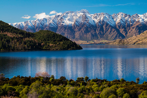 Looking across Lake Wakatipu towards the snowcapped peaks of the Southern Alps in Otago, New Zealand
