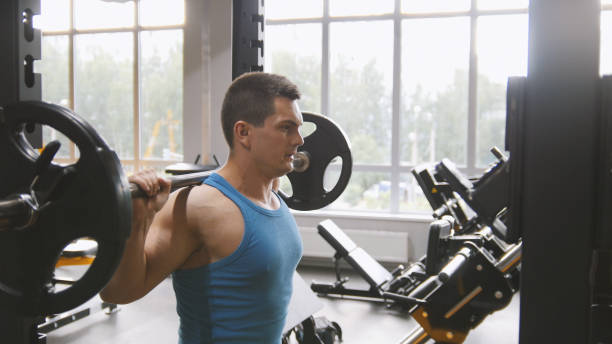 istock Fitness gym - muscular man performs squats with barbell 846303164