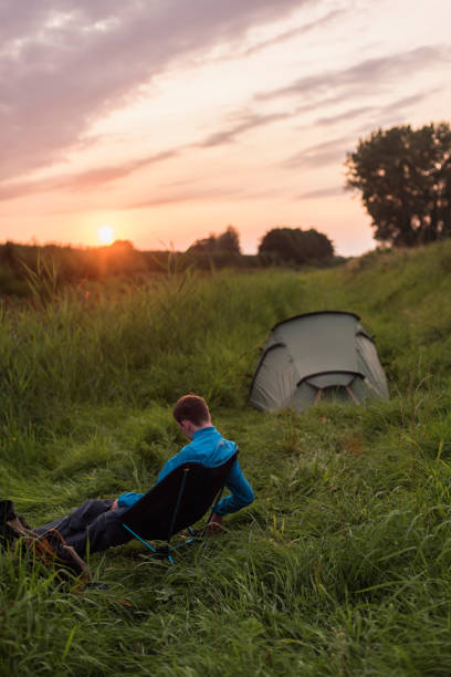 istock Young man sitting at campsite during sunset. 846306746