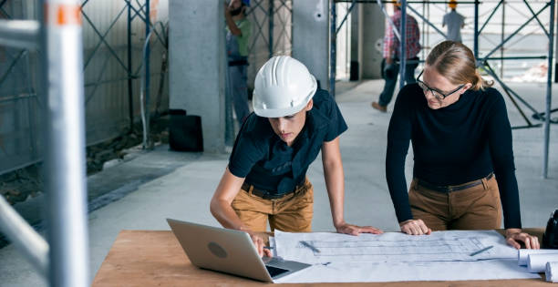 istock Female architect and female construction coordinator checking plans at construction site 846306940