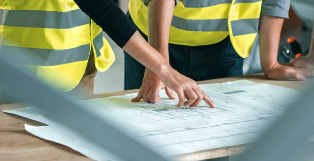 istock Male and female architect going through construction plans 846306972