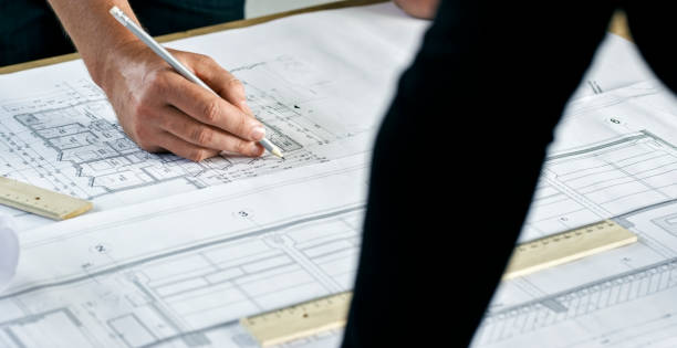 istock Hands of an architect making notes and alternating plans on table 846306996