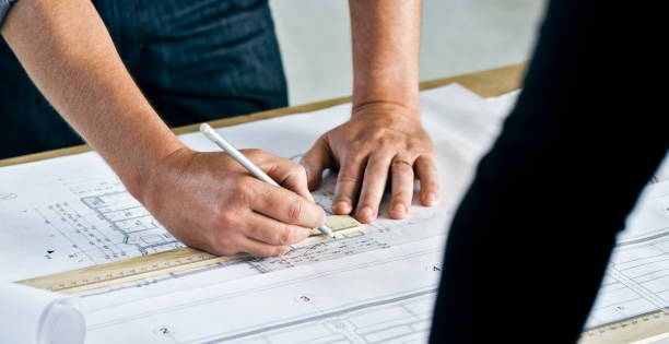 istock Hands of an architect making notes and alternating plans on table 846307052