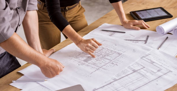 istock Male and female architect going through construction plans 846307086