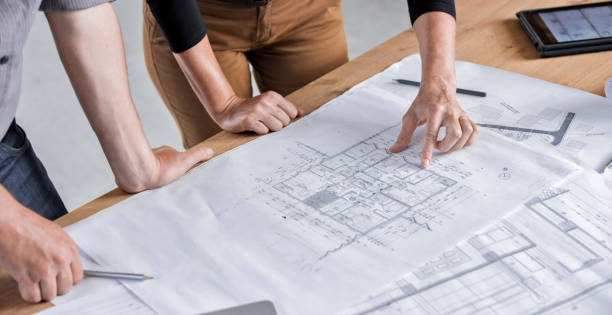 istock Male and female architect going through construction plans 846307088
