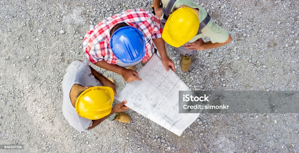 Construction Checking Three Construction Workers Checking Plans At Construction Site Stock ...