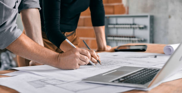 istock Male and female architect going through construction plans 846307192