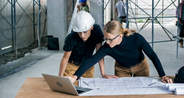 istock Female architect and female construction coordinator checking plans at construction site 846307212