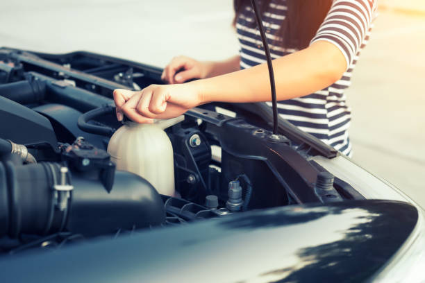Car coolant checking Women checking coolant level of car. coolant stock pictures, royalty-free photos & images