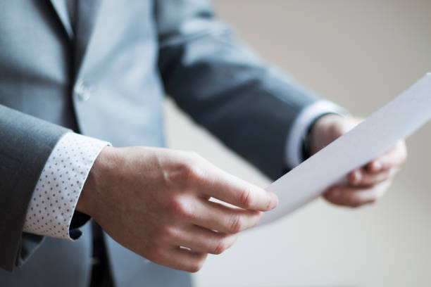istock Close up of a man's hand holding and reading paper document 846318442