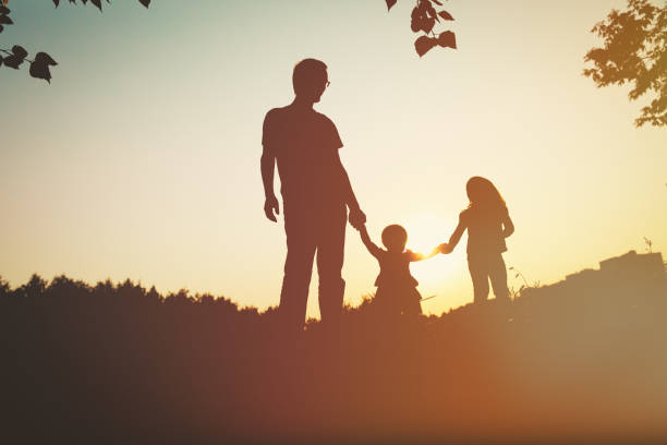 istock father with two daughters walk in sunset nature 846319028