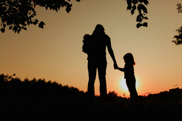istock mother with two kids walk in sunset nature 846319128