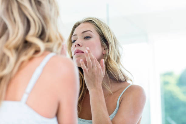 istock Focused beautiful young woman looking at herself in the bathroom mirror 846329862