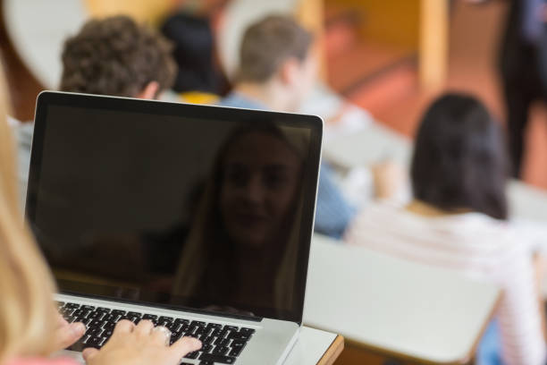 Female using laptop with students and teacher at lecture hall Rear view of a female using laptop with students and teacher at the college lecture hall men close up 20s asian ethnicity stock pictures, royalty-free photos & images