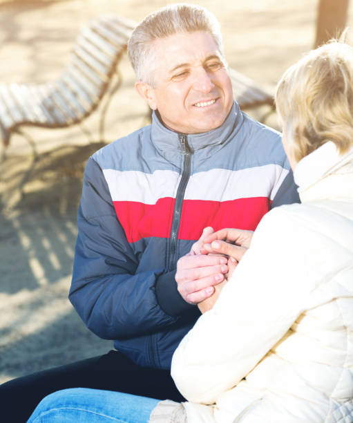 istock Husband and wife sitting on park bench 846338058