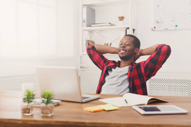 istock Relaxed black businessman with laptop in modern white office 846338614