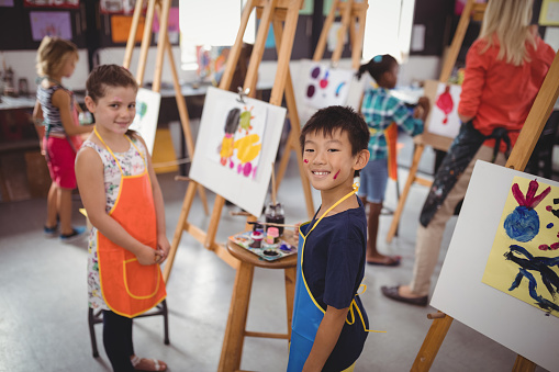 Portrait of happy schoolkids practicing drawing