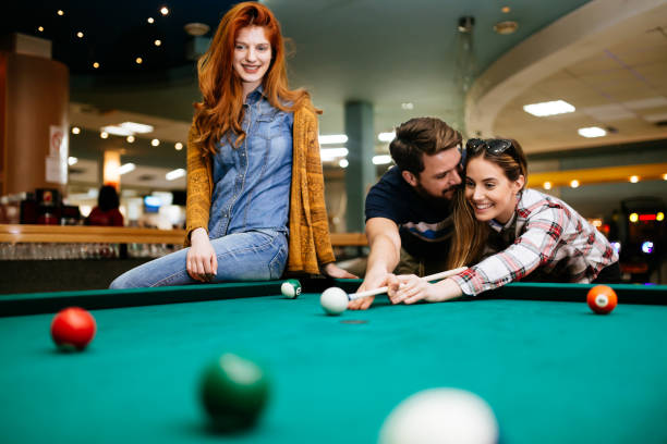 istock Happy friends enjoying playing pool 846365352
