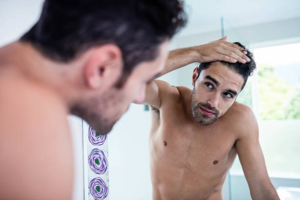 istock Handsome man looking at his hair 846369786