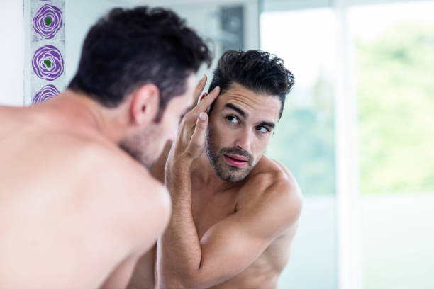 istock Handsome man looking at his hair 846369936