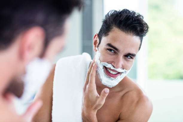 handsome man shaving his beard - shaving men shaving cream mirror imagens e fotografias de stock
