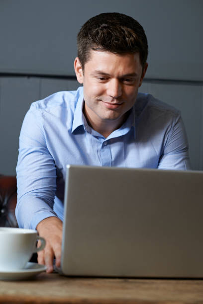 istock Businessman Working On Laptop In Internet Cafe 846373368