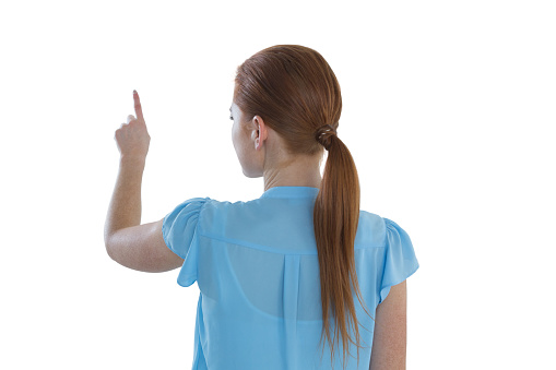 Rear view of businesswoman touching imaginary screen against white background