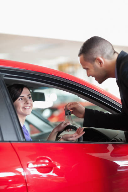 istock Smiling woman receiving car keys 846377620