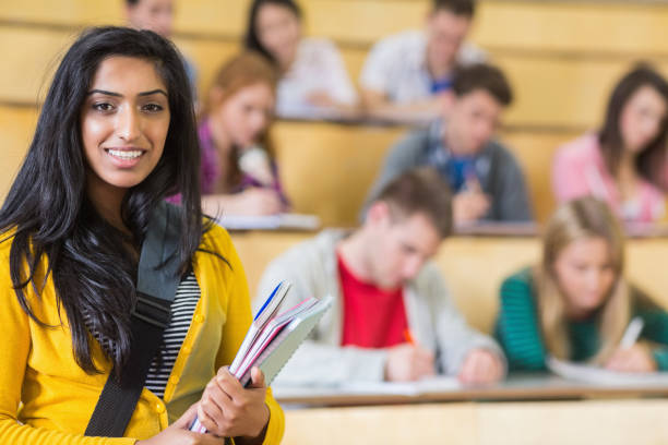 istock Smiling female with students sitting at the lecture hall 846386074