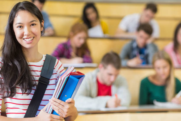 istock Smiling female with students sitting at the lecture hall 846386202