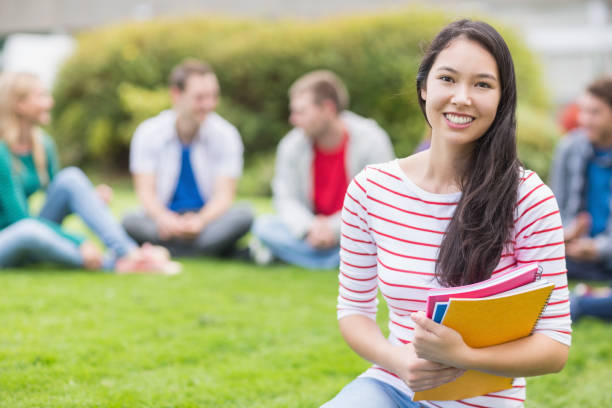 istock Smiling college student with blurred friends in the park 846388806