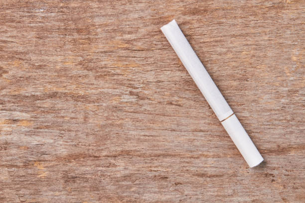 istock White tobacco cigarette on wooden background. 846398814