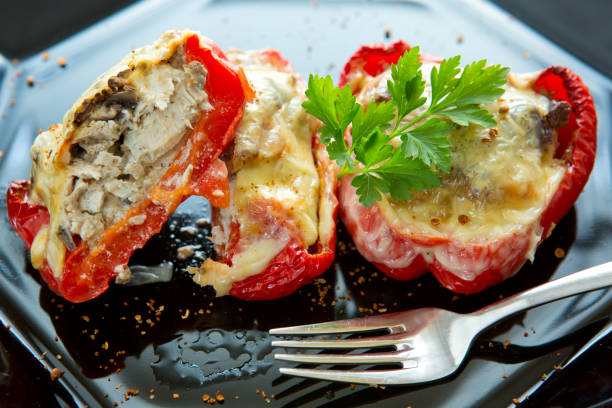 istock Stuffed Red bell peppers with mushrooms on the black plate 846399390