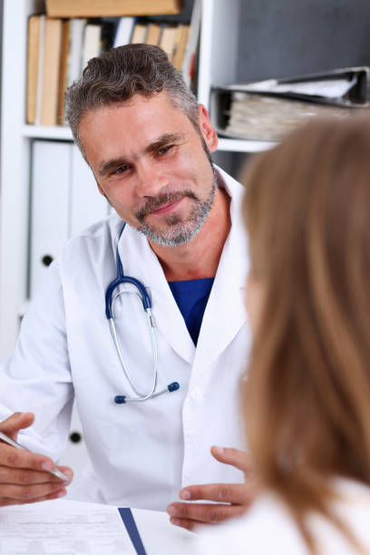 istock Smiling handsome mature doctor communicate with patient 846399662