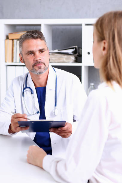 istock Smiling handsome mature doctor communicate with patient 846399686