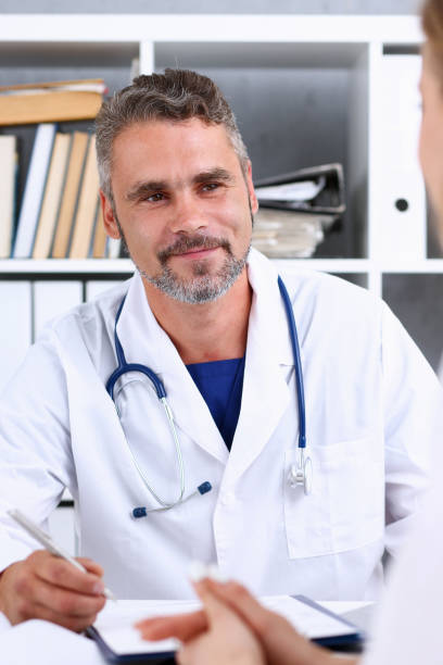 istock Smiling handsome mature doctor communicate with patient 846399932