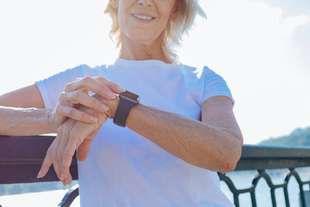 istock Smiling elderly woman looking at her smart watch 846401580