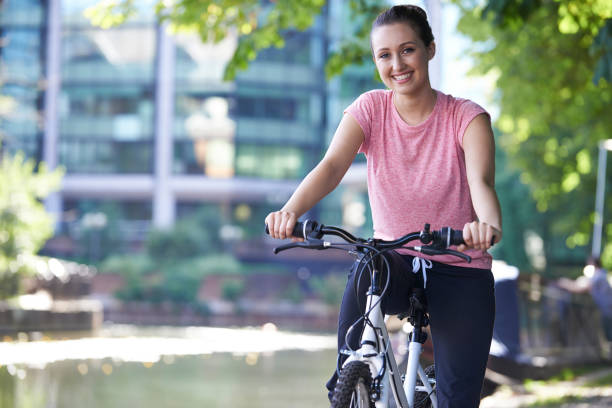 istock Young Woman Cycling Next To River In Urban Setting 846401960